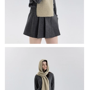 Detailed knit texture and pleats of the dark grey mini skirt and light beige scarf