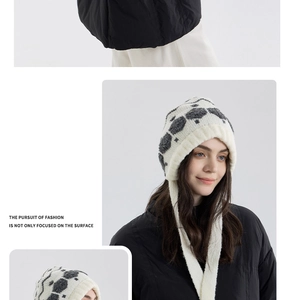 Close-up of knit snowflake hat with hexagonal pattern and side ear flaps with ties