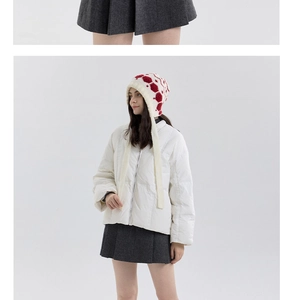 Close-up of winter knit earflap hat with red snowflake pattern and white quilted puffer jacket