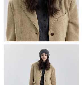 Detailed close-up showing thick herringbone wool fabric texture and brown button on a winter coat
