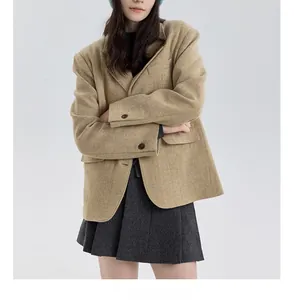 Detail view of khaki wool suit jacket paired with dark grey pleated midi skirt set