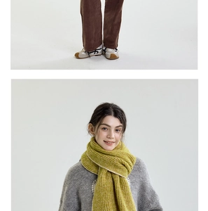 Close-up of thick ginger knit scarf with contrast edge stitching and corduroy trousers