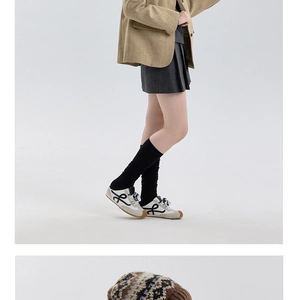 Détail d'un bonnet en tricot Fair Isle marron avec un blazer kaki et une jupe plissée