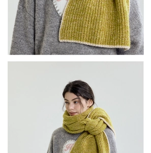 Close-up of knit lime green scarf with cream piping and soft gray sweater texture