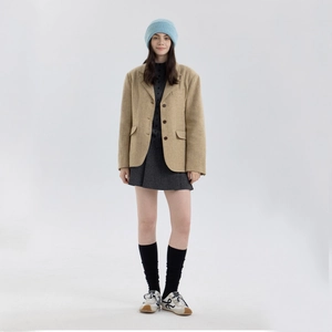 Woman in thick wool knit beanie and tan wool blazer with grey dress for winter style