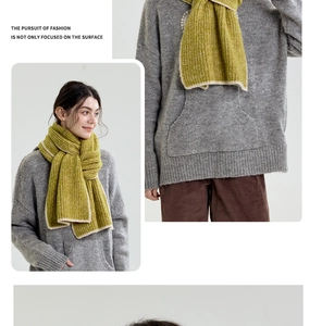 Close-up of thick grass green knit scarf with contrasting cream border and ribbed texture