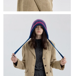 Detail van de blauw en paars gestreepte gebreide muts met lange oorflapriemen voor de winter