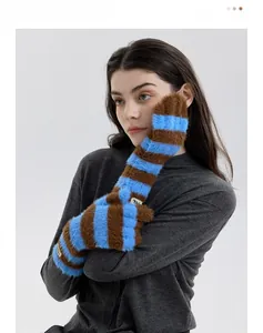 Close-up of blue and brown striped plush knit gloves with soft fuzzy texture detail