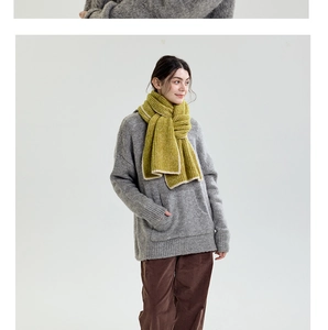 Detail of yellow-green knit scarf with contrast edge design and coarse rib texture