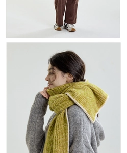 Detail of green knitted scarf with cream trim and thick wool texture in casual style