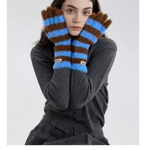 Close-up of blue and brown striped knit gloves with plush texture and woven logo tag