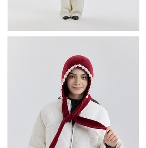Close-up of red knit balaclava with white pearl trim and adjustable tie fastening