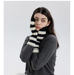 Close-up of black and white striped plush gloves with branded label on the cuff
