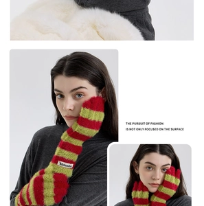 Close-up of fluffy red and green striped knit gloves with plush texture for winter fashion