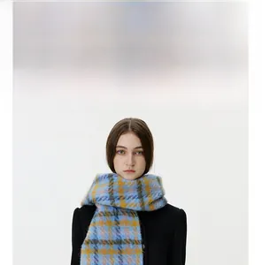 Close-up of thick knitted plaid scarf in blue and yellow showing fluffy mohair texture