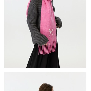 Details des pinken Strickschals mit Quasten und elegantem Perlen-Schleifen-Accessoire