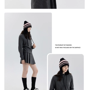 Dettaglio del cappello in maglia a righe rosa e nere con paraorecchie per il calore invernale