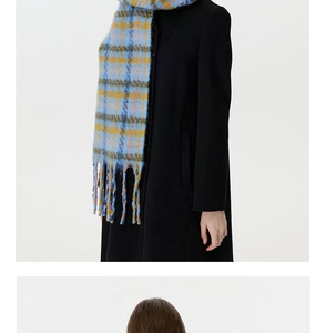 Detail of blue and yellow plaid scarf with thick tassels over a black coat