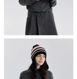 Dettaglio del set in maglia grigia e cappello a righe nero e rosa con paraorecchie