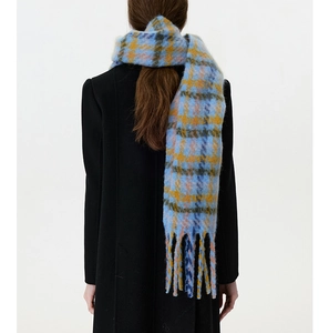 Detail of soft sky blue and orange plaid scarf with fringe tassels on a black coat