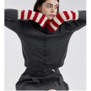 Close-up of red and white striped faux fur gloves with soft knitted texture and plush cuffs