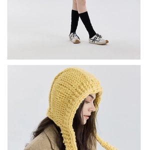 Detail der Strickstruktur der senfgelben Balaclava-Mütze mit warmen Ohrenklappen