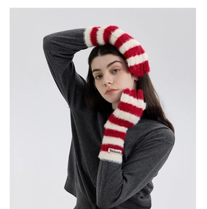 Detail view of red and white striped faux fur arm warmers with a soft plush texture