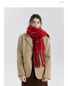 Detail of red wool blend knit scarf with long tassels and premium brand label
