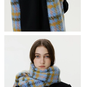 Close-up of thick brushed plaid scarf featuring blue, yellow, and grey checkered knit texture