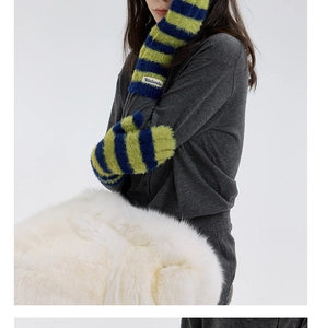 Detailed macro view of soft blue and green striped plush knit winter gloves with brand label