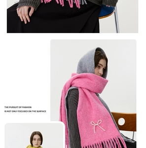 Detailansicht des rosa-grauen Strickschals mit glitzernder Schleife und Fransen