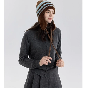 Dettaglio del cappello da aviatore in maglia con strisce blu e paraorecchie invernali