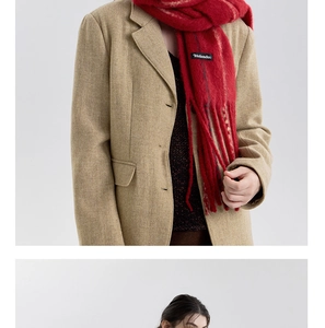 Detail of red wool blend scarf with fringe and brand label on a khaki blazer