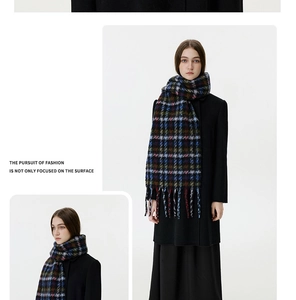 Detailed close-up of thick winter scarf with plaid pattern and long tassel accents