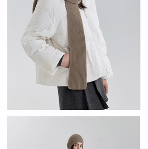 Detail view of brown ribbed knit scarf and beanie paired with white puffer jacket