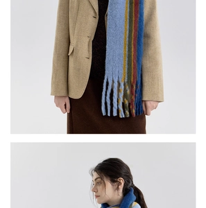 Detail of colorful striped wool blend scarf with fringe tassels on winter coat