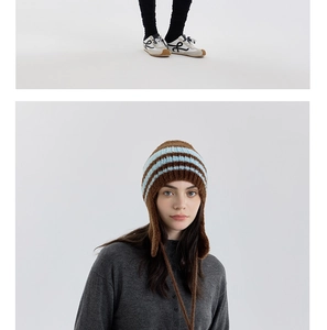 Dettaglio cappello in maglia a righe con paraorecchie, laccetti e stile collegiale