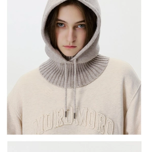 Close-up of beige sweatshirt with 3D embossed lettering and grey knitted balaclava detail