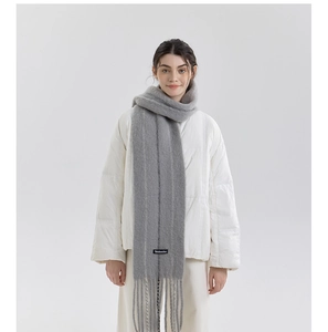 Detail showing soft light grey wool blend scarf with fringe tassels and brand logo tag