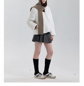 Detailed view of women's vintage sneakers with logo and textured thick knit scarf ensemble