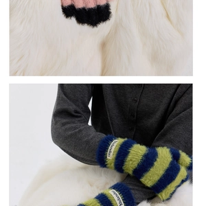 Close-up of fluffy striped knitted gloves with soft faux fur texture and brand woven label