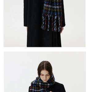 Close-up of colorful checkered wool-like scarf with long fringe and tassels detail