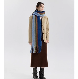 Detail of colorful plaid wool blend scarf with long tassels and thick warm texture