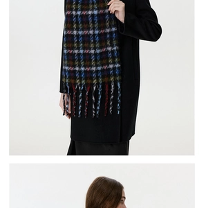 Detailed close-up of soft brushed houndstooth scarf texture with fringed tassel edges