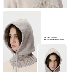 Detail of beige knit balaclava showing soft texture and ribbed drawstring with metal tips