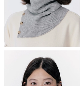 Detailed view of grey knitted neck warmer with stylish brown decorative buttons