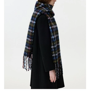 Detailed texture of thick brushed houndstooth scarf with blue and green fringe tassels