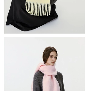 Detailstruktur eines dicken gelben Winter-Schals mit langen Fransen und weichem Griff