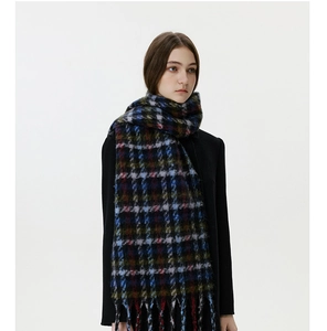 Close-up of winter thick brushed plaid scarf with long tassels and soft mohair texture