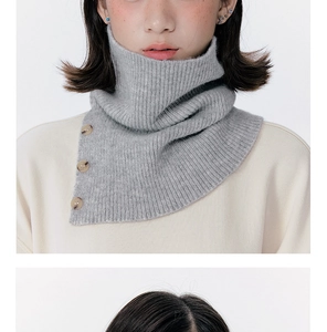 Detail of grey knitted neck warmer with ribbed texture and three amber buttons